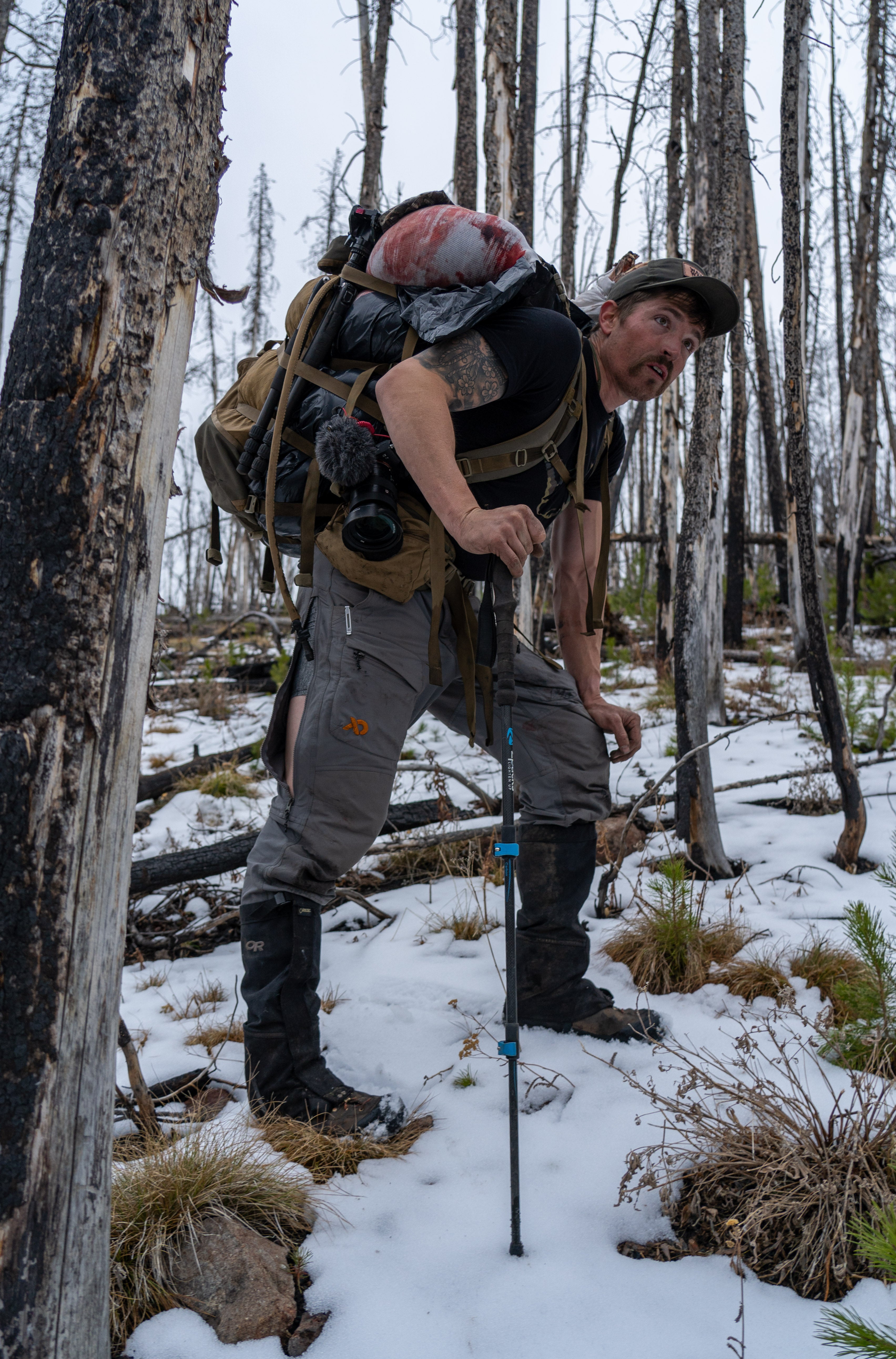 A man pausing in a snowy mountain while hiking